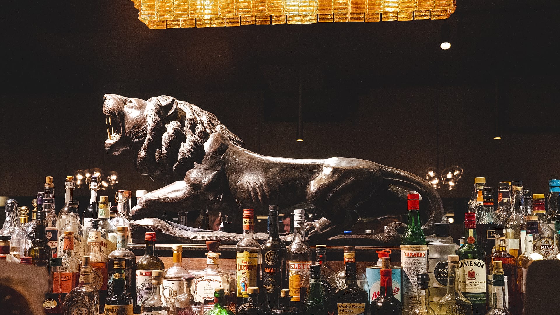 Notte Ristorante bar with lion sculpture and warm chandelier lighting