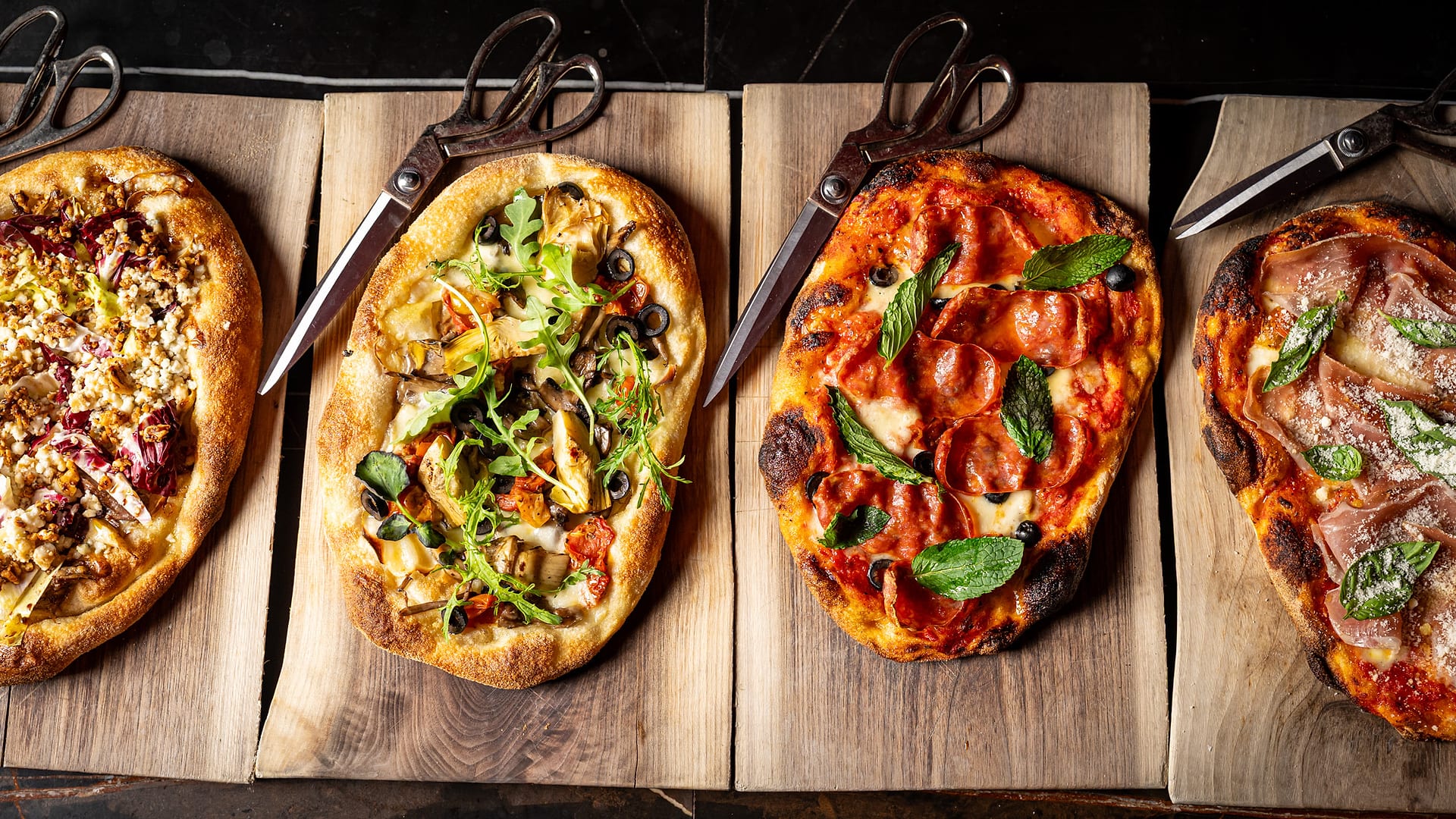Roman-style pizzas on wooden boards at Notte Ristorante